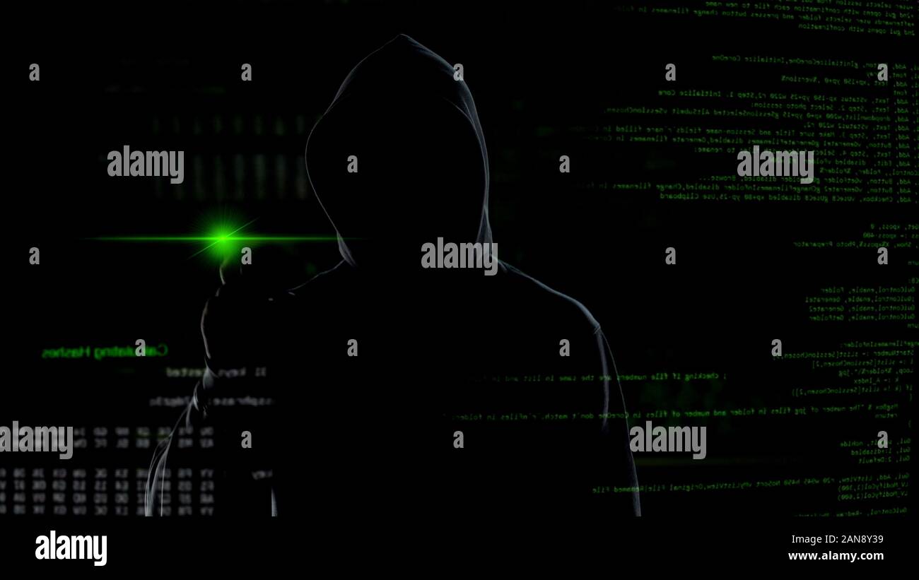 Man in hood push button on virtual screen with scripts, anonymous cyber attack Stock Photo