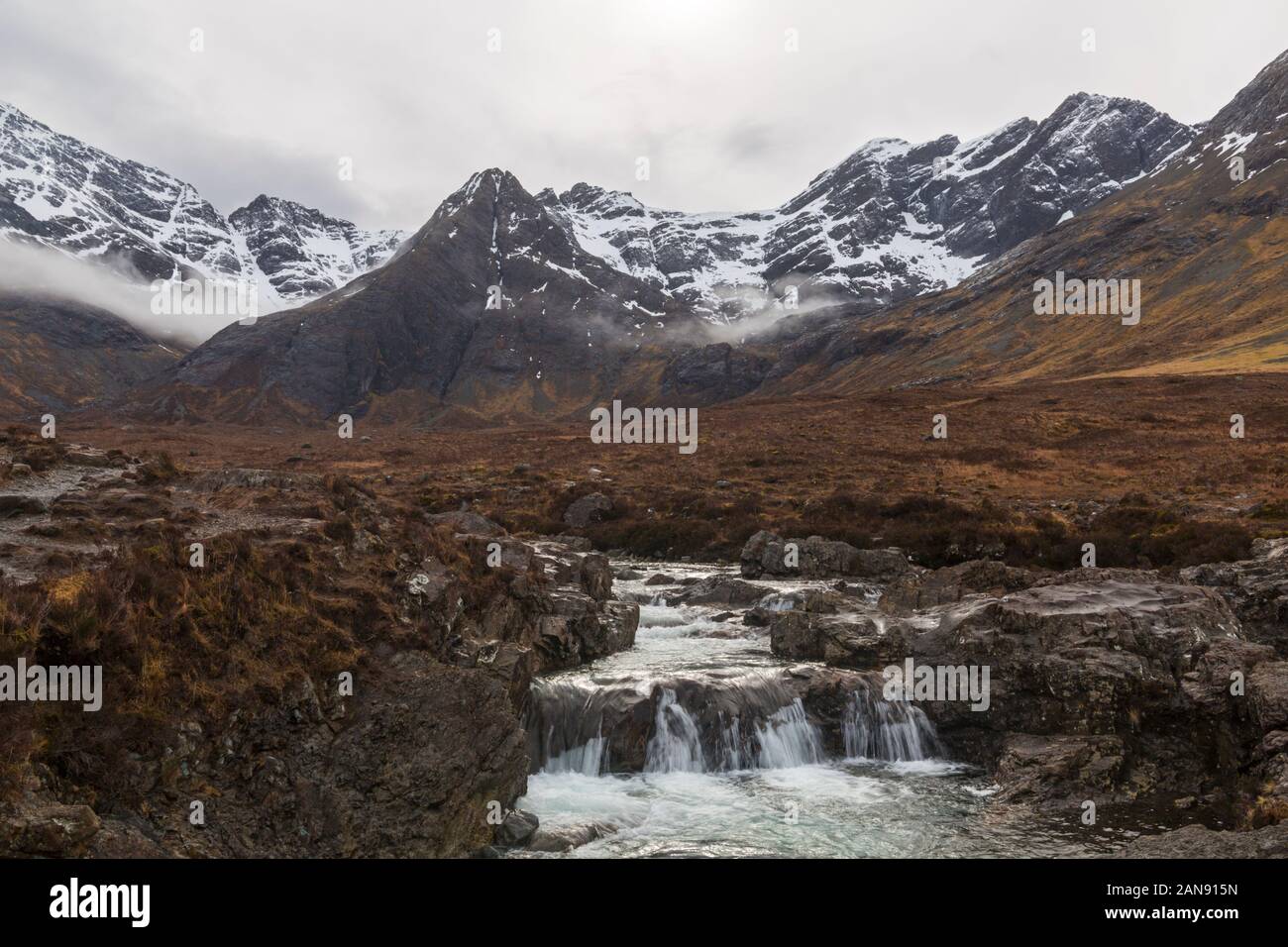 Fairy Pools with mist over the Black Cuillin mountains with waterfalls at the river Brittle, Isle of Skye, Scotland, UK in March Stock Photo