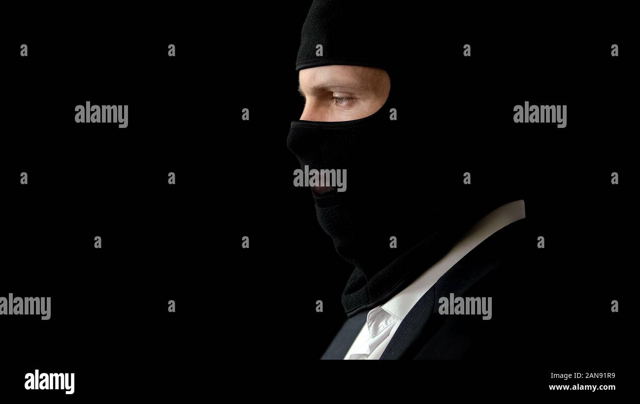 Gangster in suit and balaclava ready for crime, illegal business deal