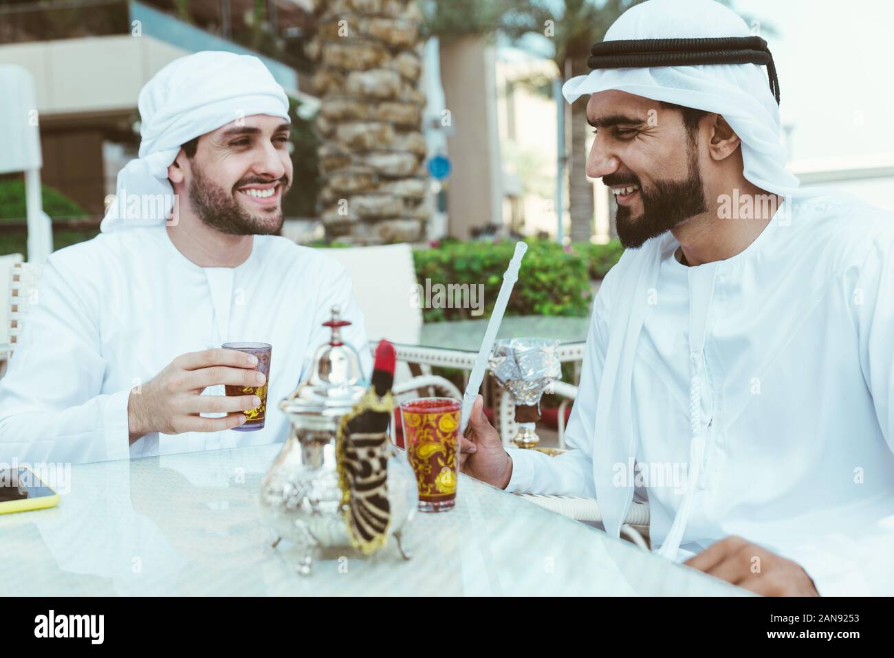 two young businessmen going out in Dubai. Friends wearing the kandura traditional male outfit in Marina Stock Photo