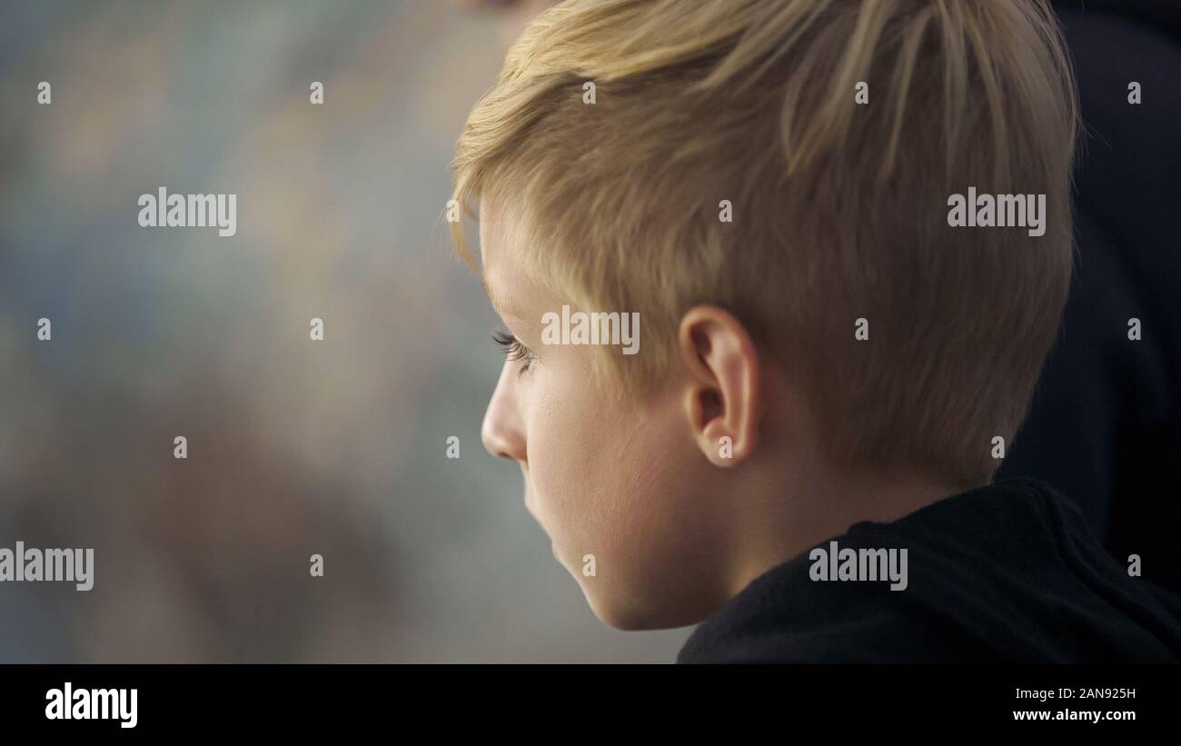 Little football fan watching match at stadium, supporting favorite team, league Stock Photo