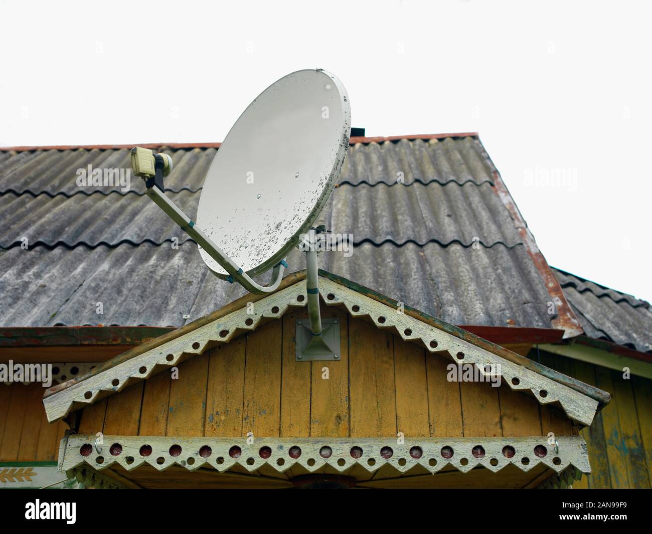 Retro looking satellite dish mounted on a top of old wooden building