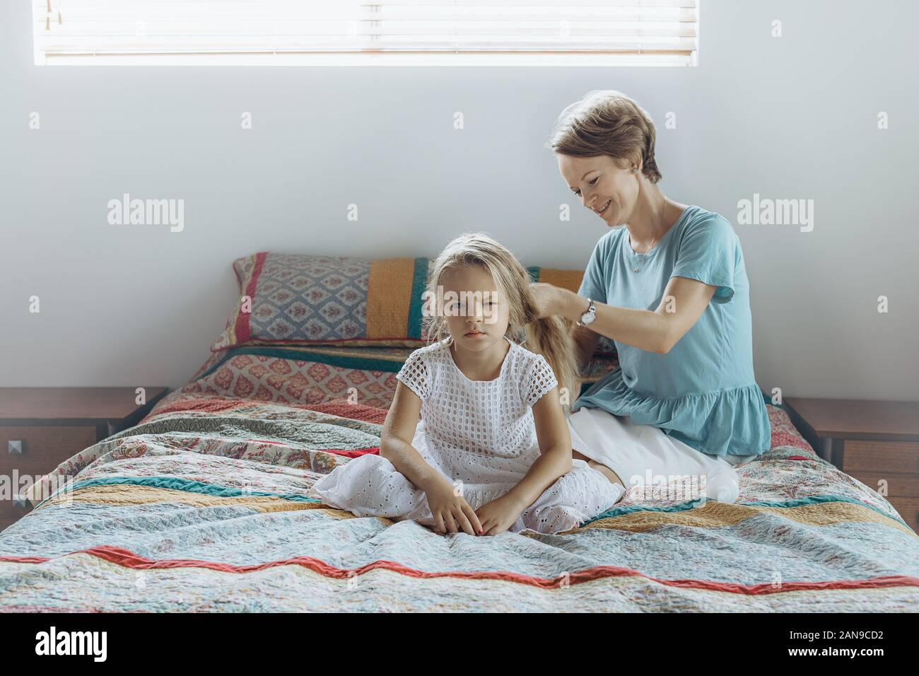 Mother Do Hair Braid To Her Daughter On The Bed Stock Photo Alamy
