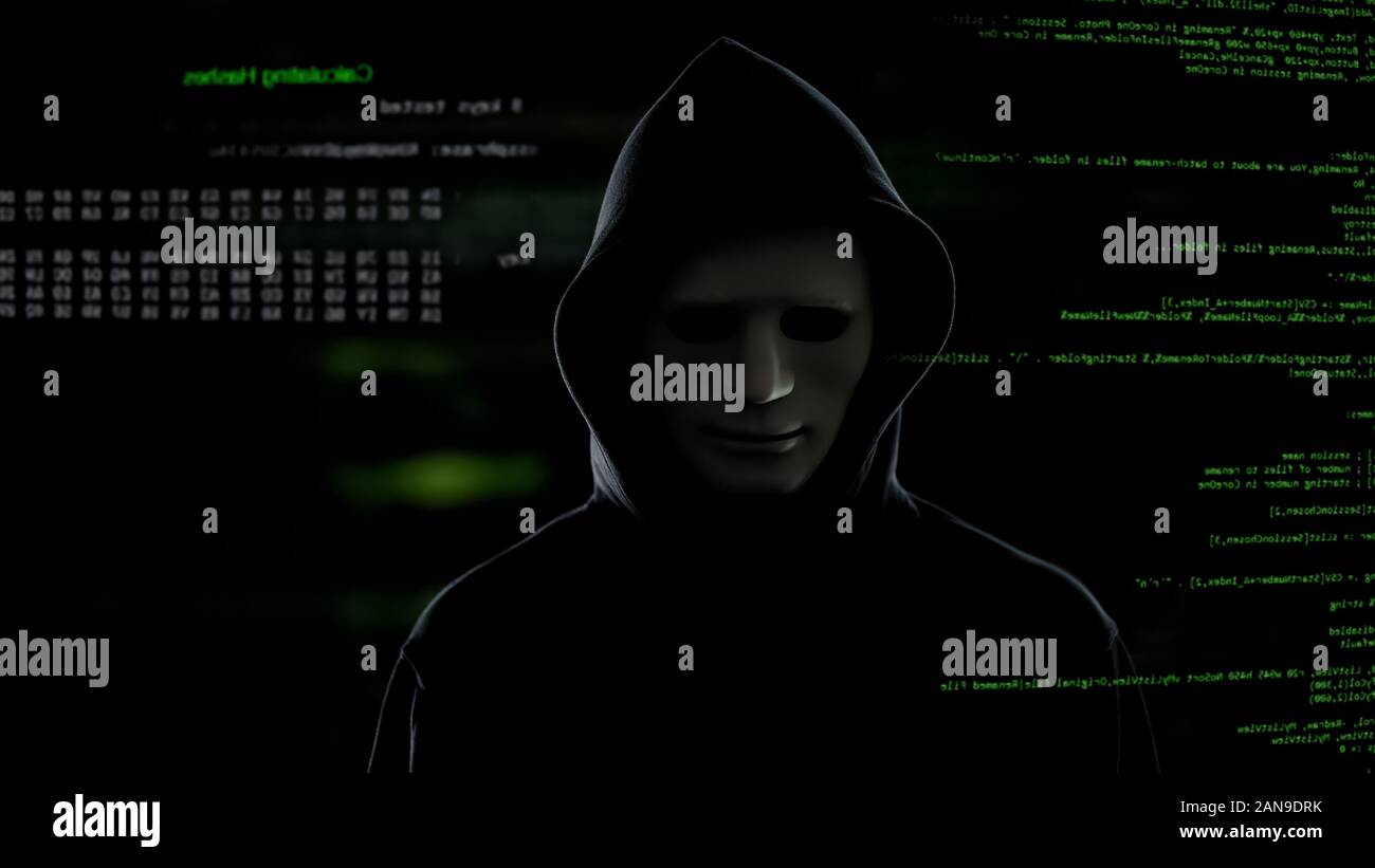 Hacker in white mask stealing important information from server terrorist attack Stock Photo