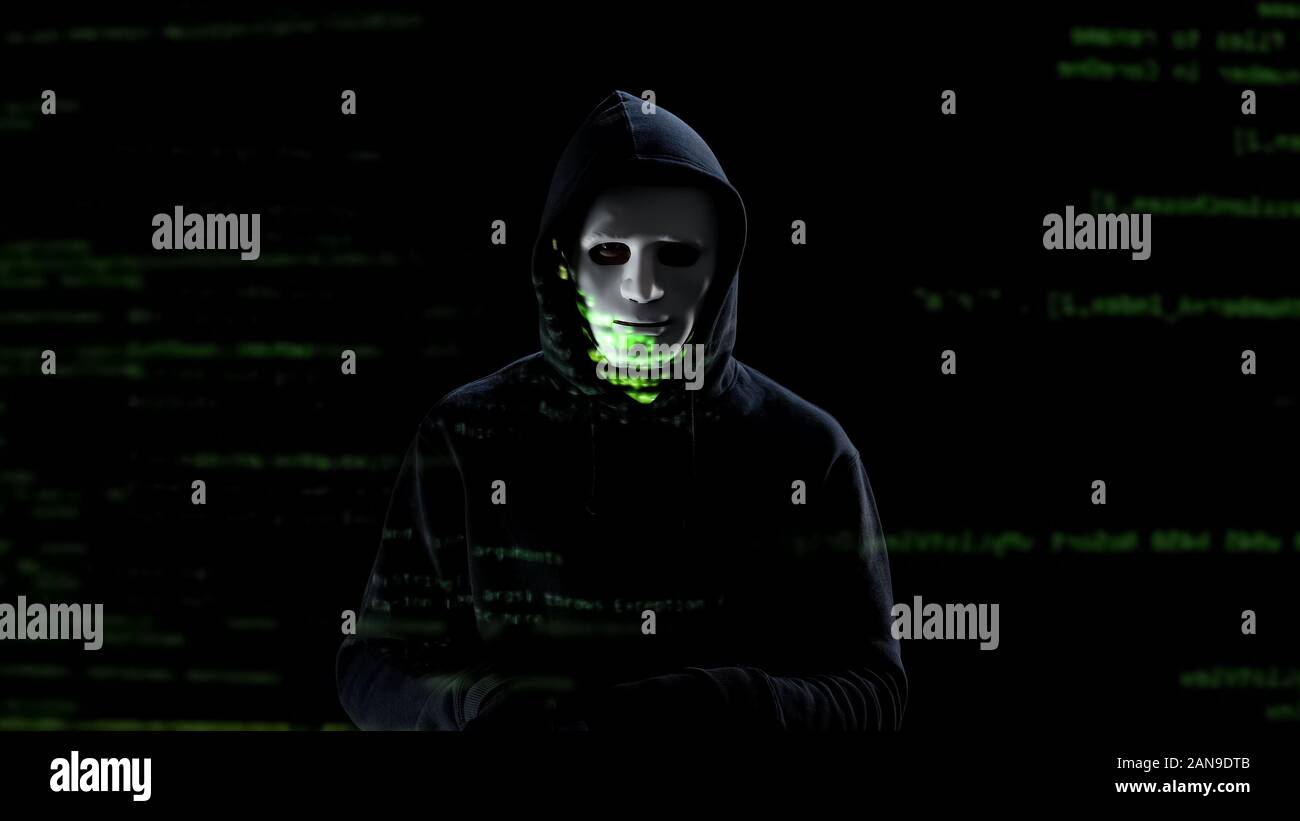 Professional hacker in white mask stealing personal data from pc, threat Stock Photo