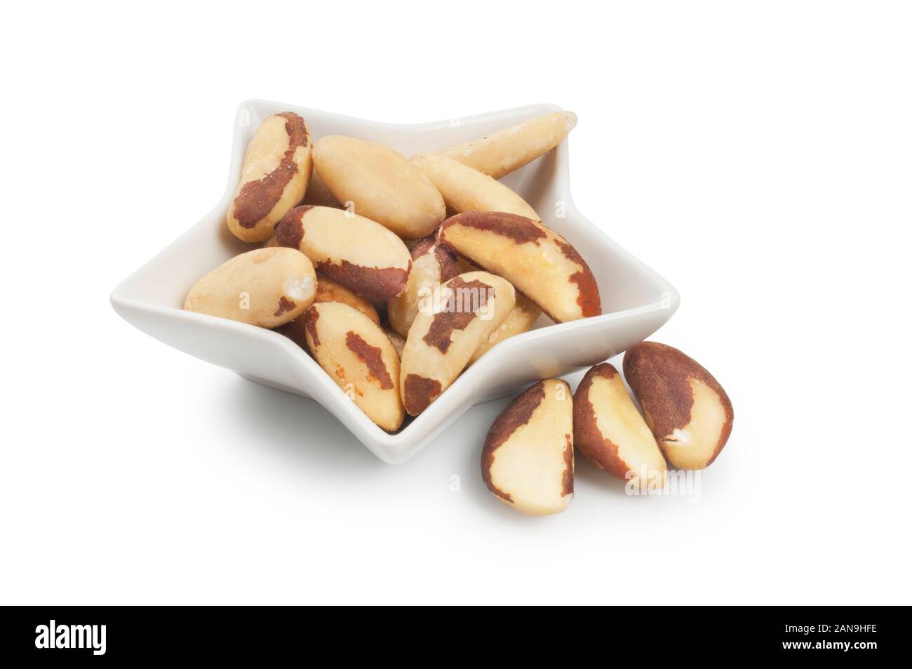 Studio shot of peeled Brazil Nuts in a small white dish isolated on a white background Stock Photo