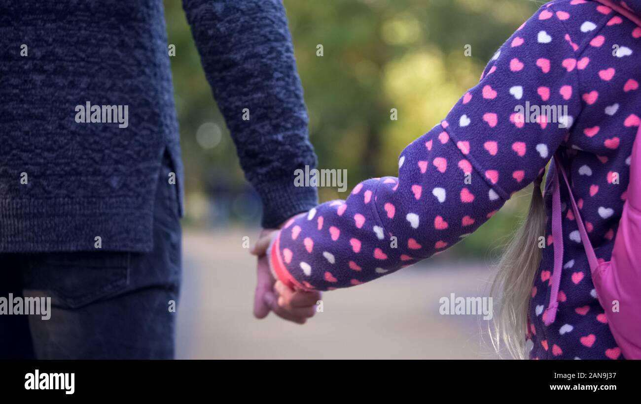 Single father and daughter holding hands and walking forward together ...