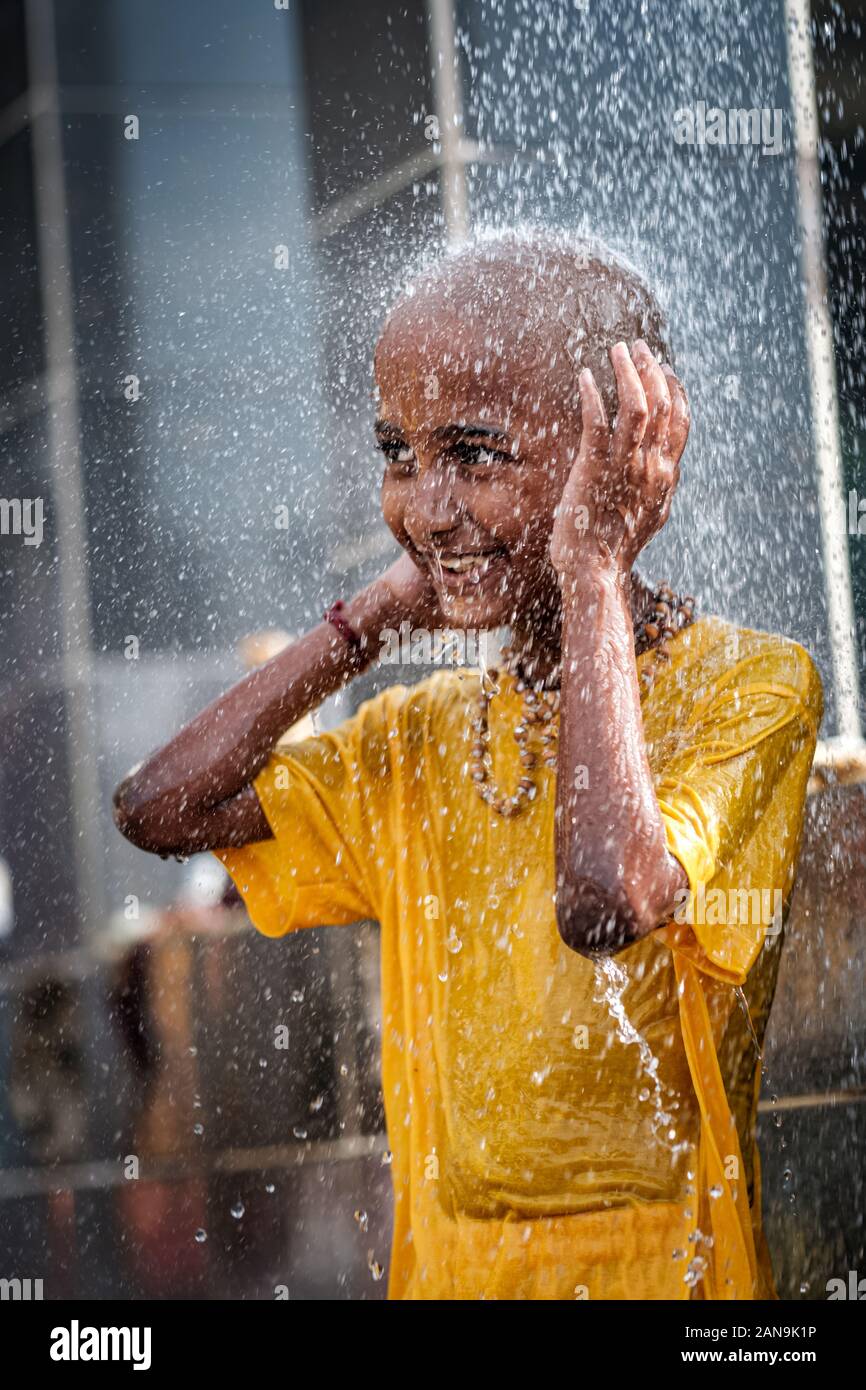 Batu Caves, Malaysia - January 21 2019 : Close-up of young boy devotee having shower ritual in Thaipusam Festival. Stock Photo