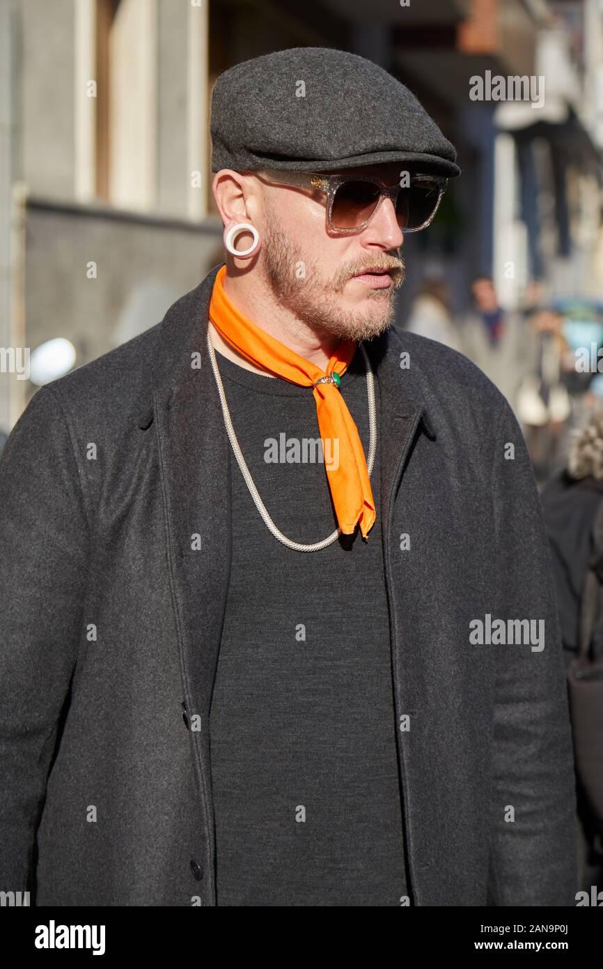 MILAN, ITALY - JANUARY 12, 2019: Man with orange neckerchief and black jacket before Etro fashion show, Milan Fashion Week street style Stock Photo