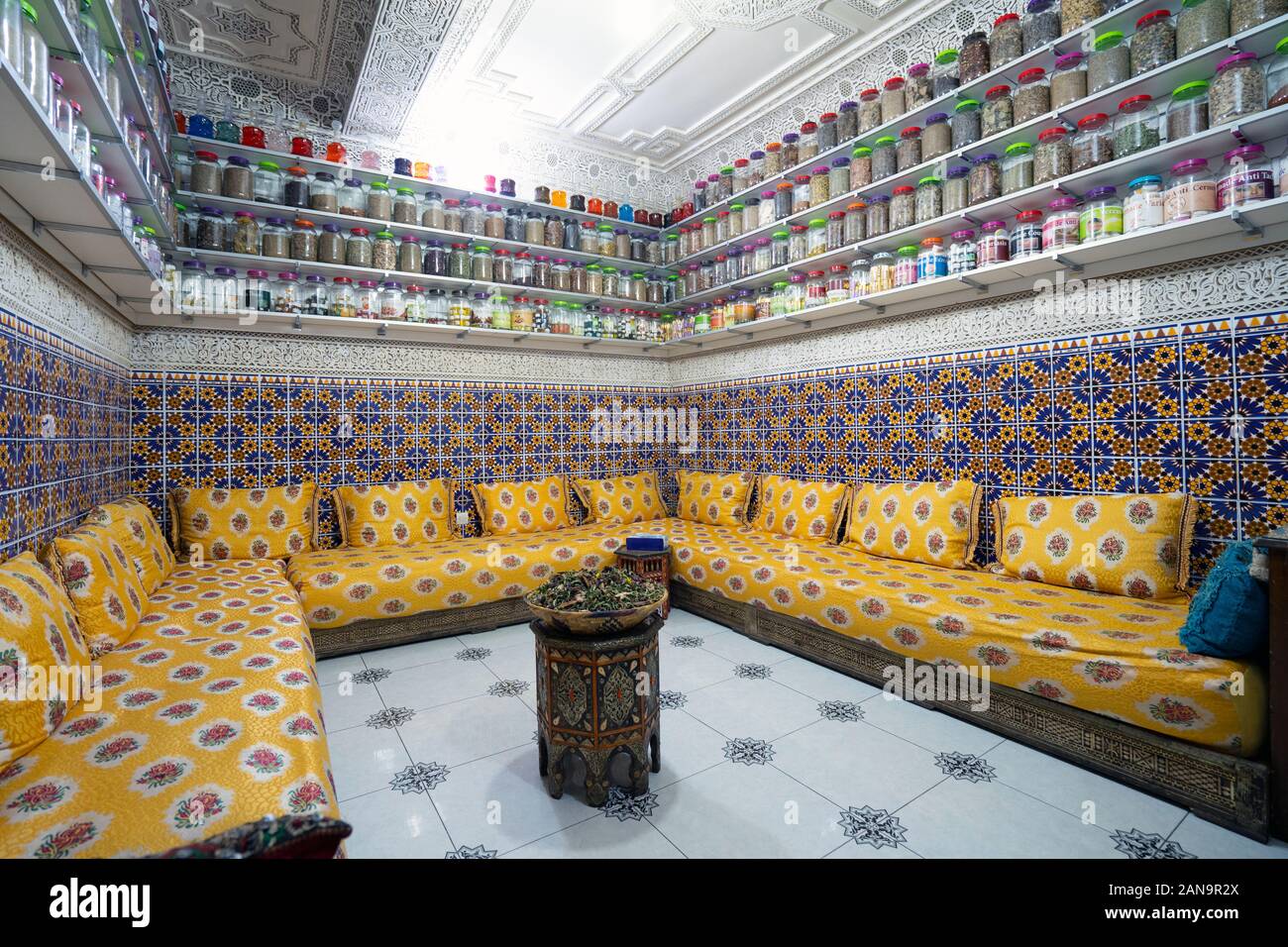 Moroccan interior with variety of spices on shelves and herbal tea in the middle of the room Stock Photo