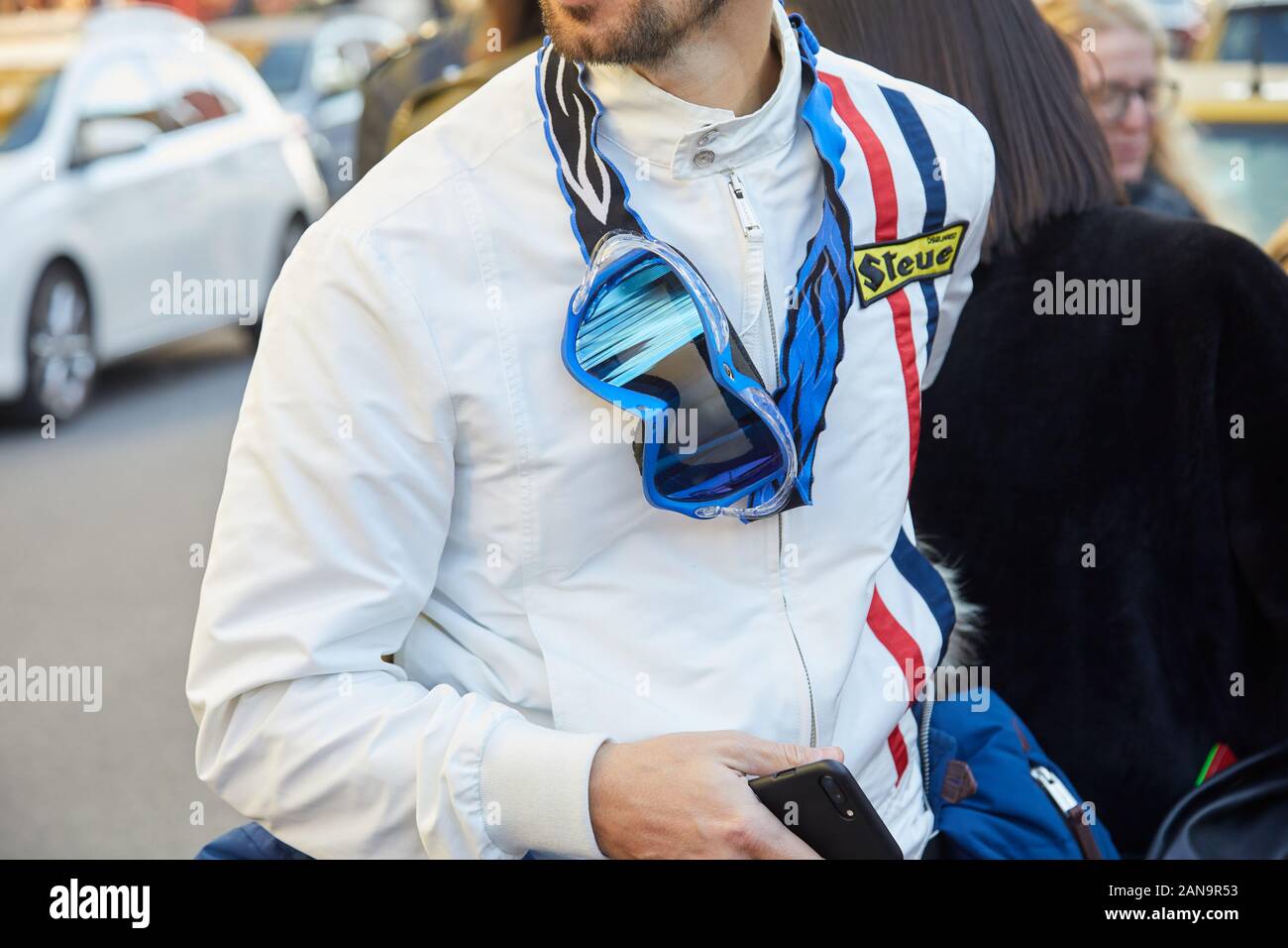 MILAN, ITALY - JANUARY 12, 2019: Man with white leather jacket with blue motorbike sunglasses before Msgm fashion show, Milan Fashion Week street styl Stock Photo
