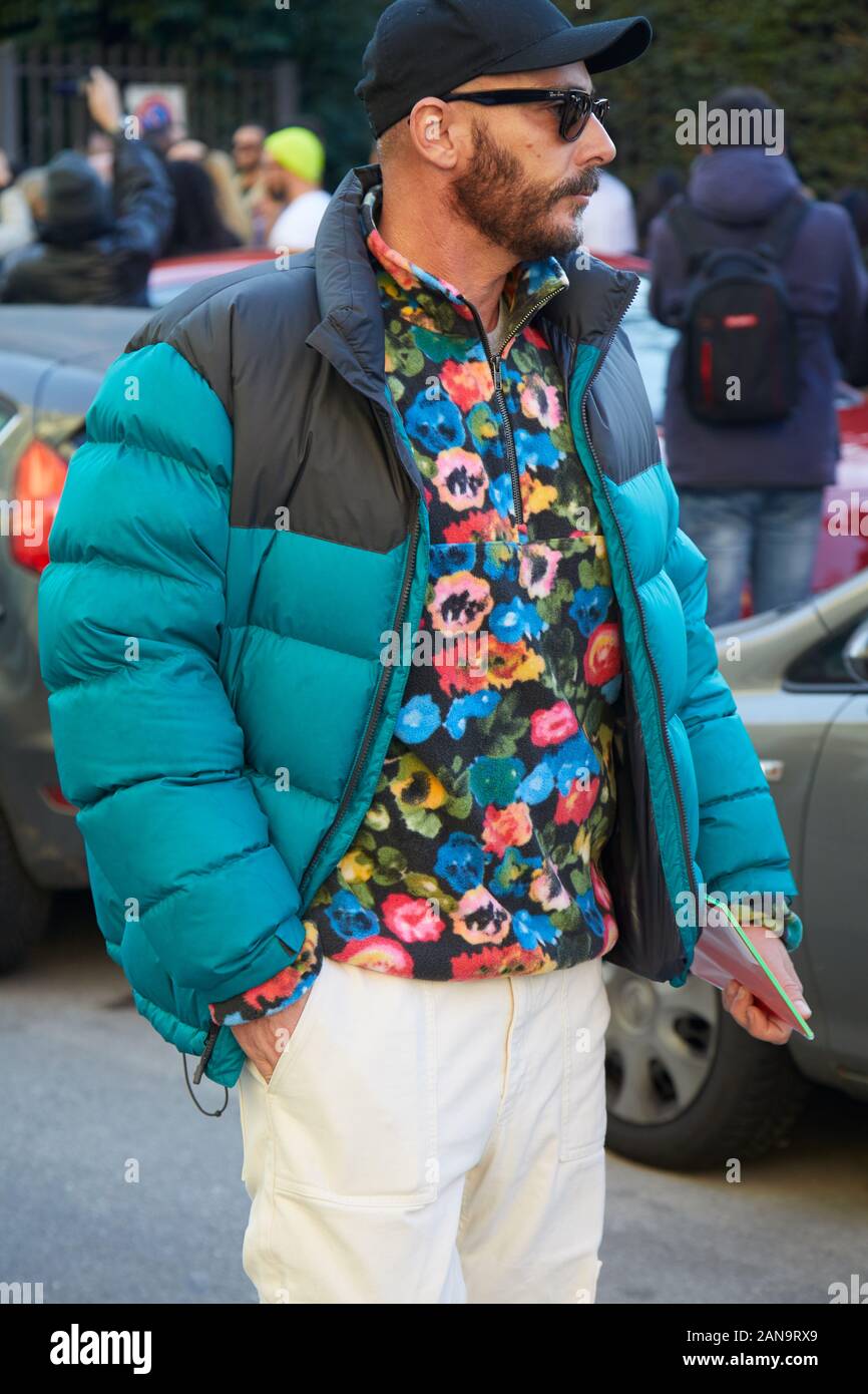 MILAN, ITALY - JANUARY 12, 2019: Man with black and blue padded jacket and floral shirt before Msgm fashion show, Milan Fashion Week street style Stock Photo