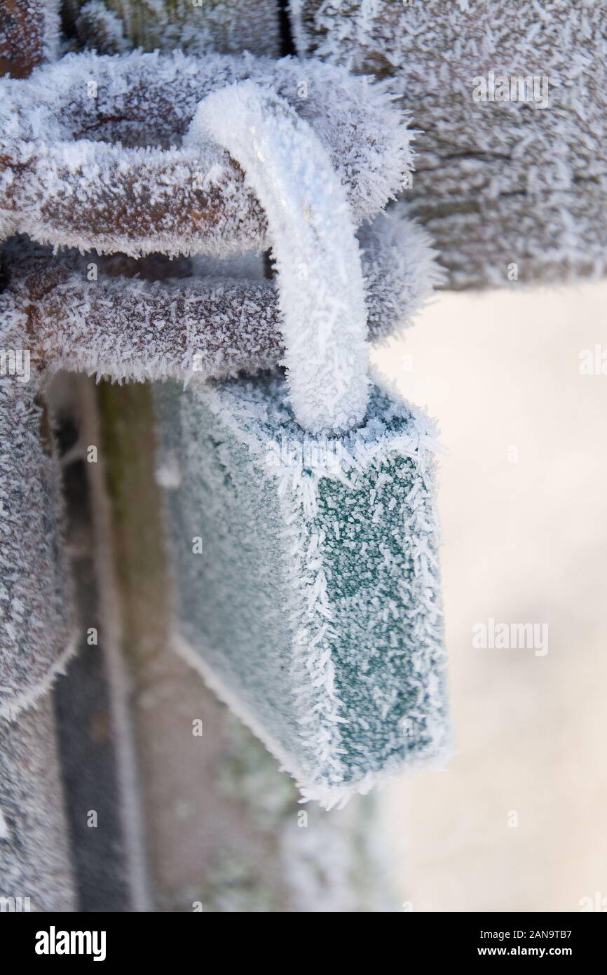 A frosty lock on the entrance to a park that is closed for winter. Stock Photo