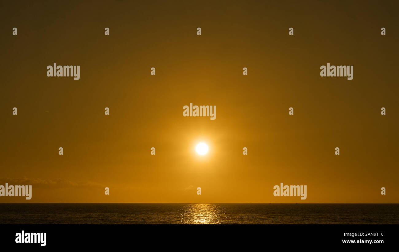 The Sun above the sea horizon in the sky - Orange natural background Stock Photo