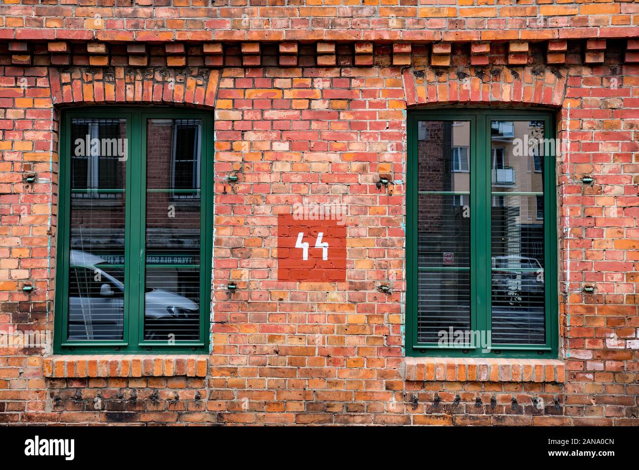 Old electricity sign painted on a wall between two windows Stock Photo