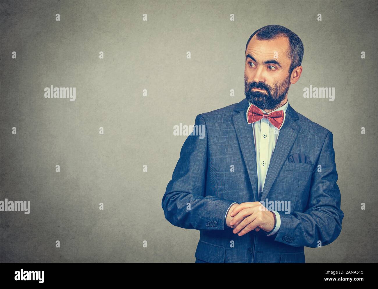 Businessman looks worried surprised, shocked, stunned to the side blank copy space. Mixed race bearded man, model isolated on gray studio wall backgro Stock Photo