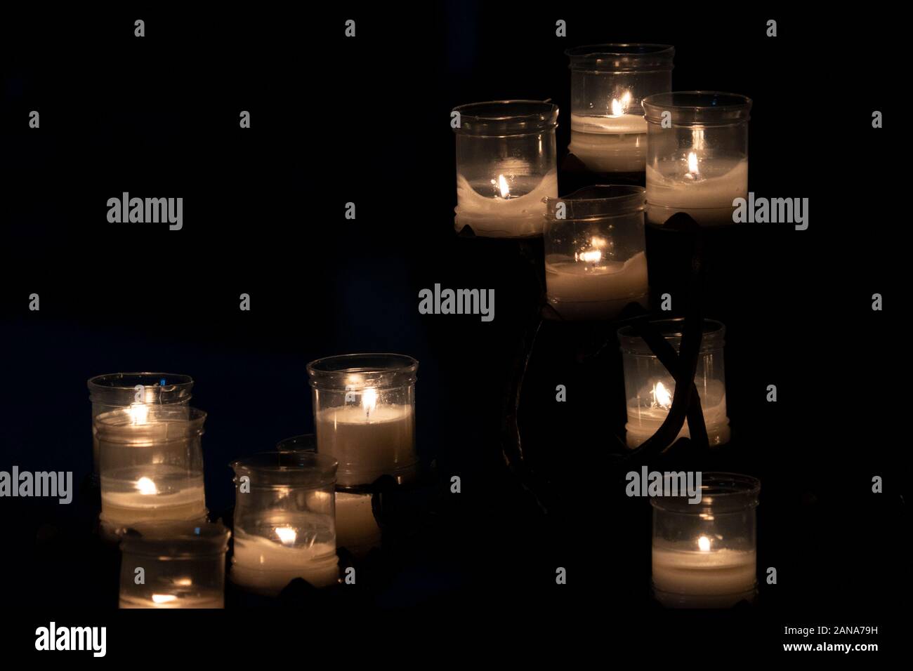 votive candles inside a church isolated on black background Stock Photo