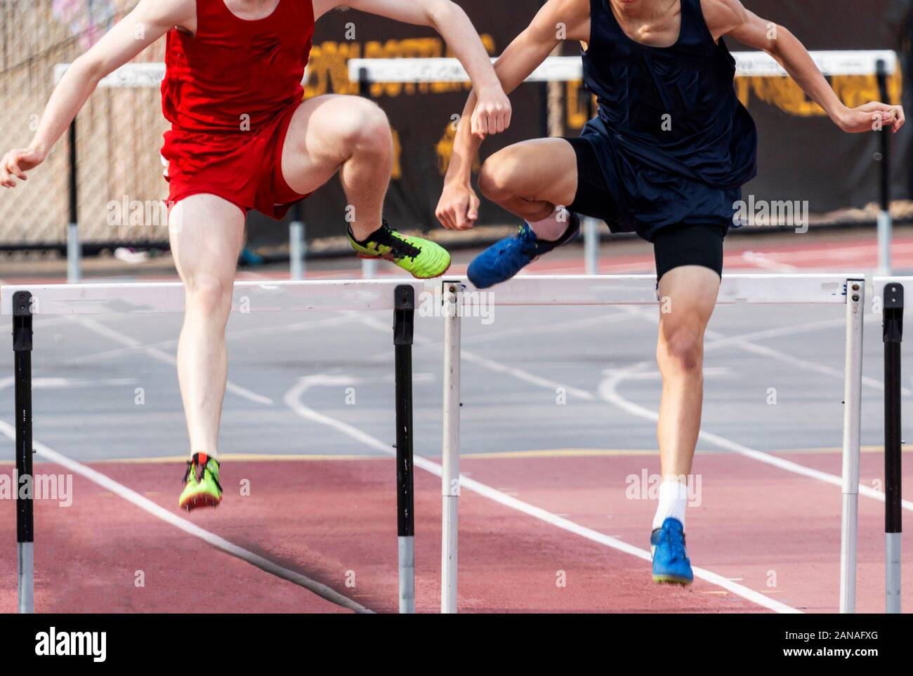 Two high school boys are even as they enter the final straightaway