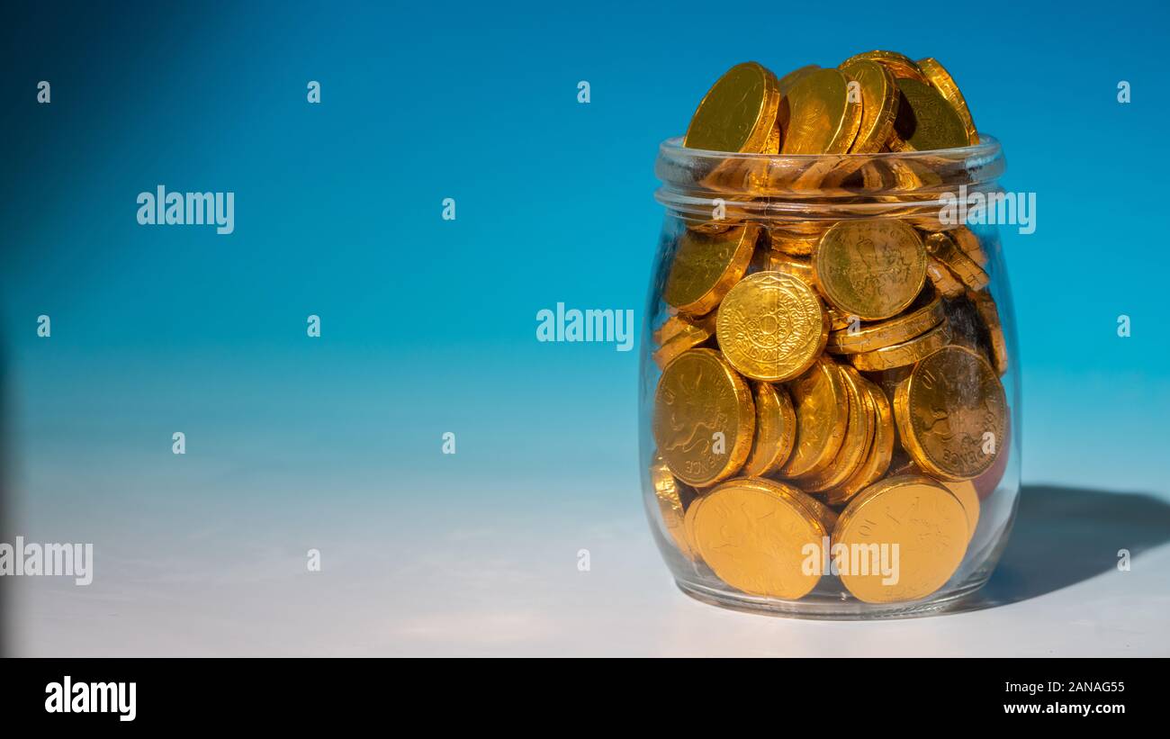 Glass jar full of gold coins Stock Photo