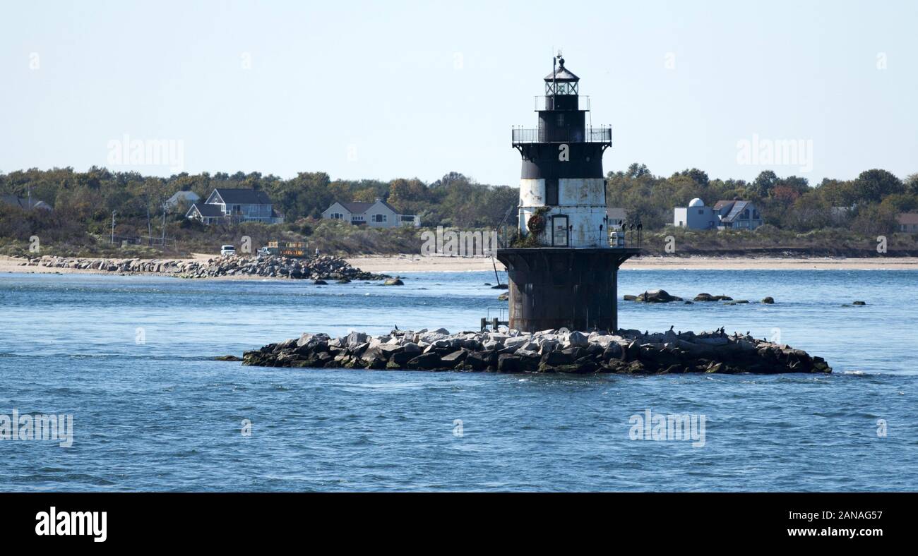 The Orient Point Lighthouse taken from the water with Orient Point in the background Stock Photo