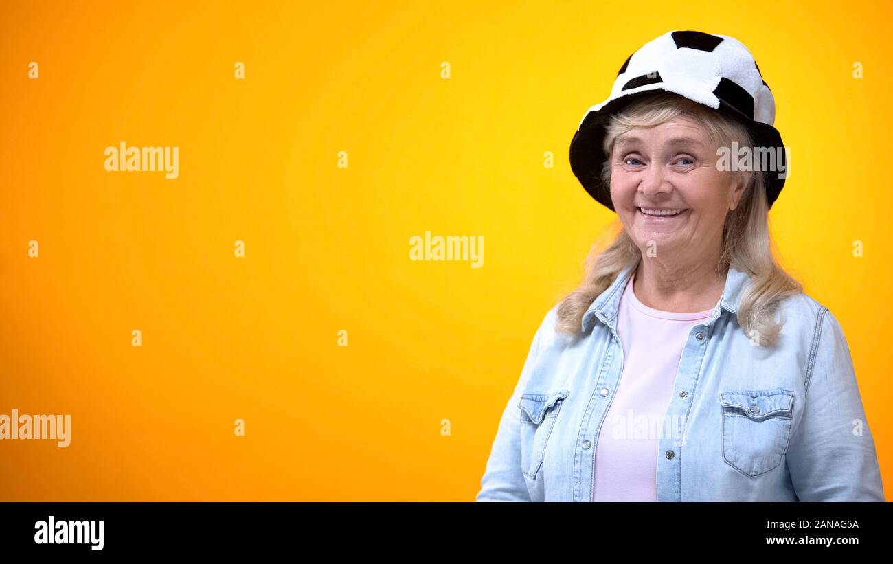 Smiling old woman wearing funny football hat, template for ad, sport betting Stock Photo