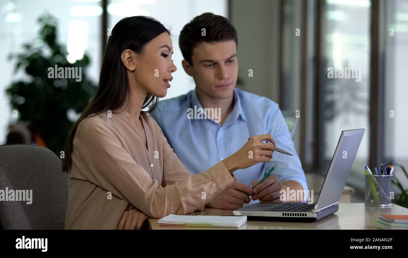 Multiethnic colleagues discussing new project looking laptop, business team Stock Photo