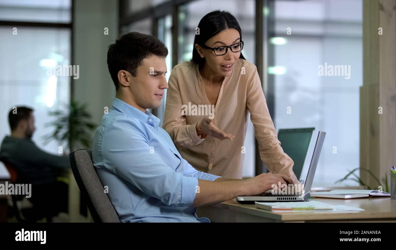 Two colleagues working on laptop, team cooperation on web development project Stock Photo