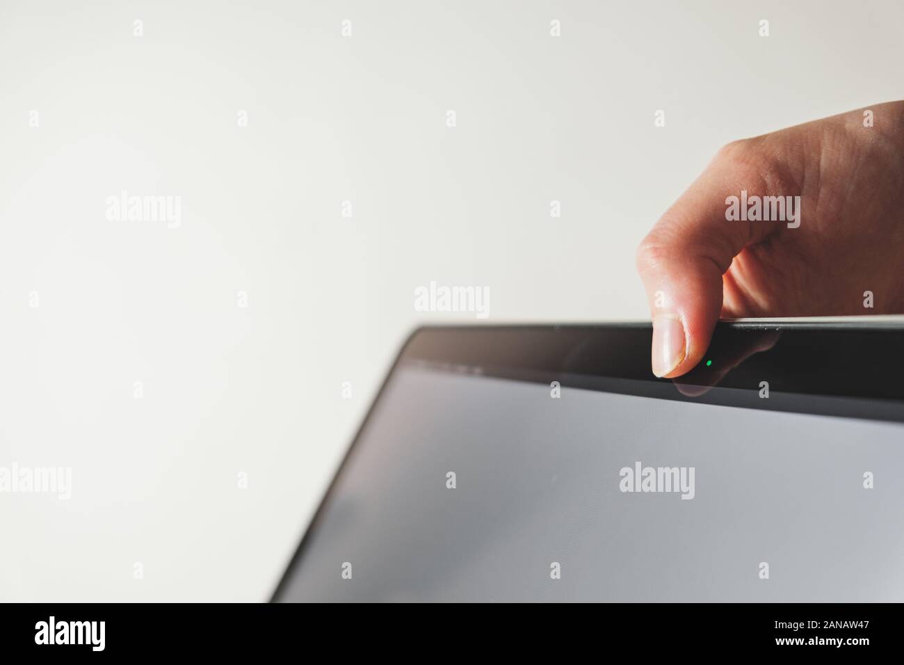 Thumb covers up the webcam of a computer. Concept of privacy, online security of a firewall Stock Photo