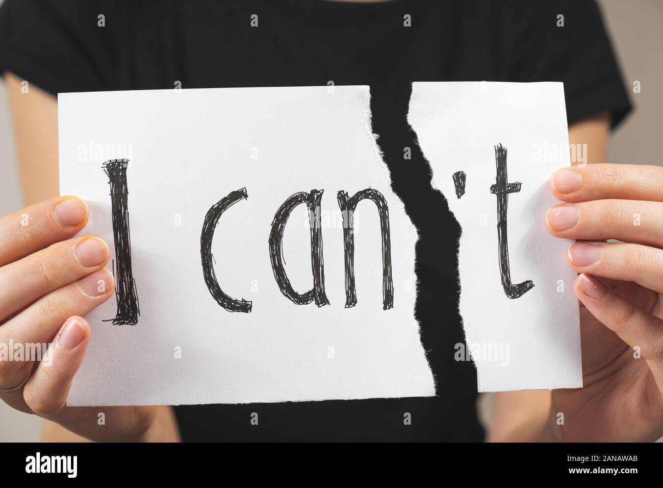 Hands tearing out negation of the 'i can not' sign. Motivational concept of believing in yourself and overriding problems and emotional difficulties Stock Photo