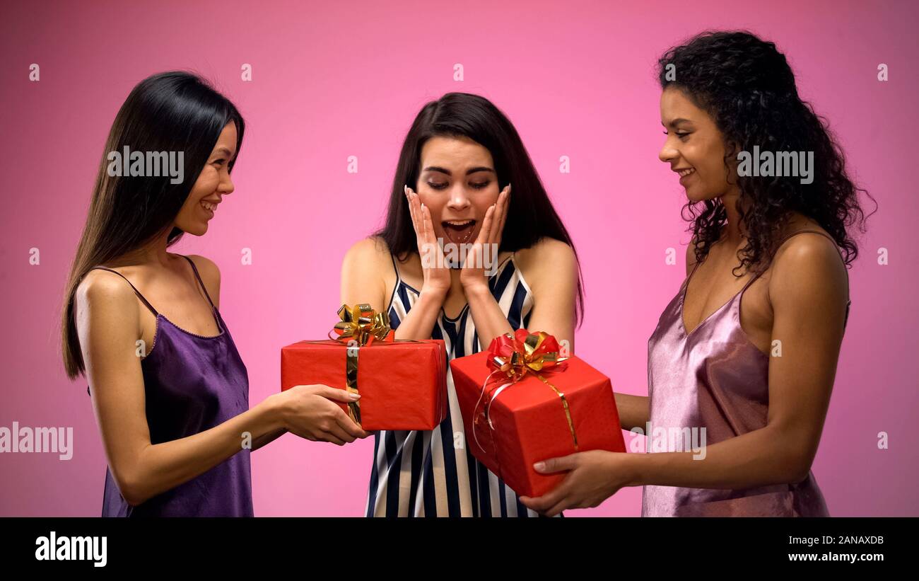 Women giving present to surprised friend, all-girl birthday party