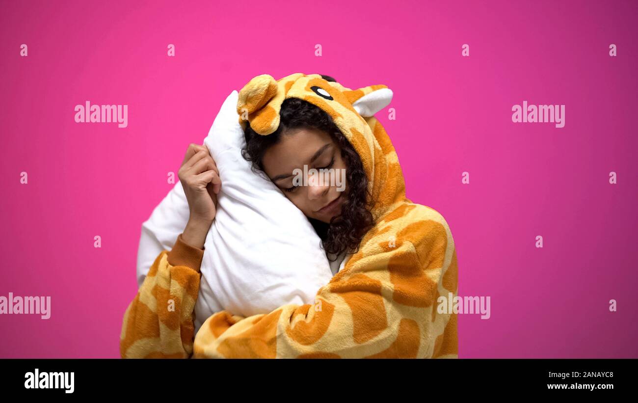 Beautiful woman sleeping in giraffe pajamas, comfortable clothes for night sleep Stock Photo