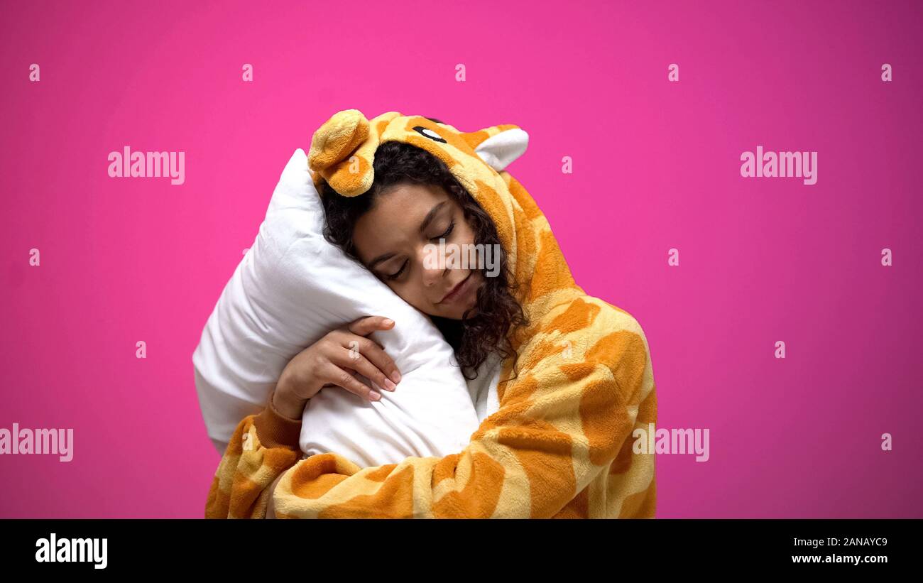 Afro-american woman in giraffe pajamas sleeping and smiling, feeling comfort Stock Photo