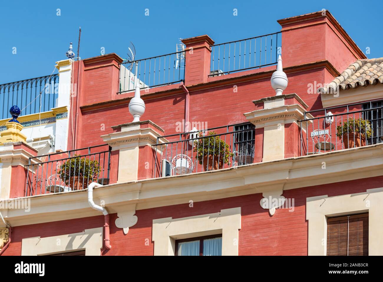 A colourful roof terrace tops off a deep pink building overlooking Plaza del Salvador in Seville Stock Photo