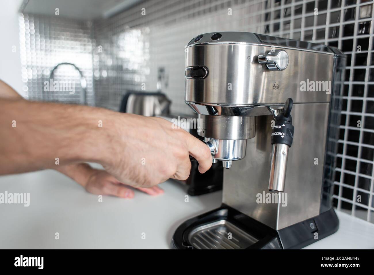 Guy prepare delicious aromatic coffee in a coffee machine. A simple way