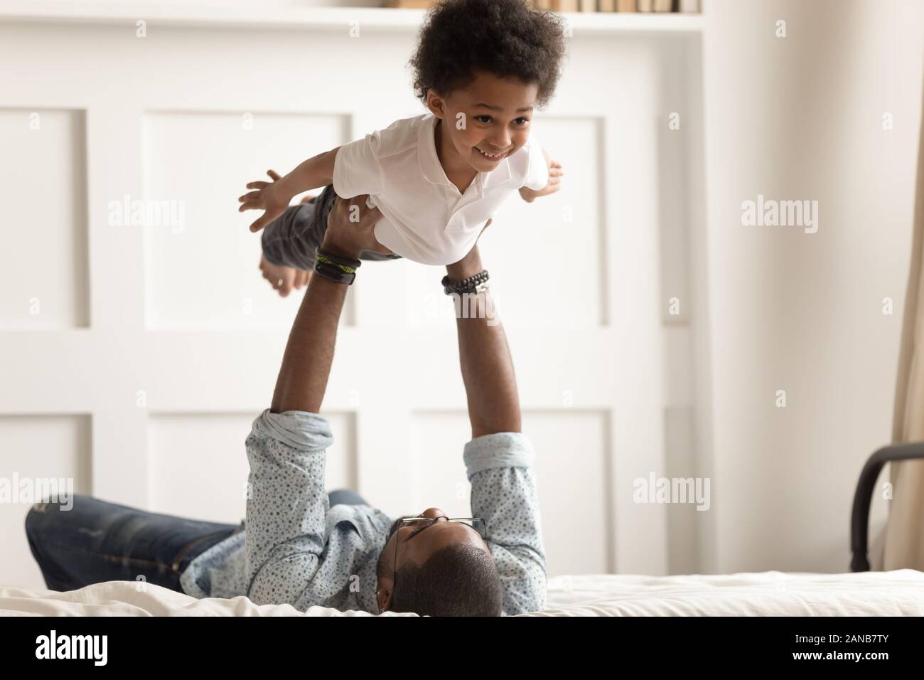 Cute funny black boy flying in strong fathers hands Stock Photo Alamy