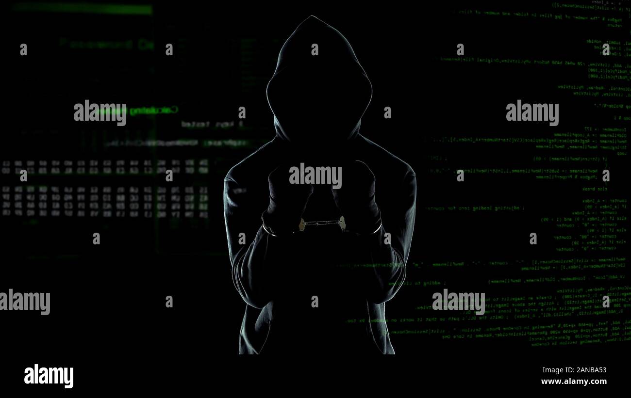 Silhouette of handcuffed angry hacker on animated computer code ...