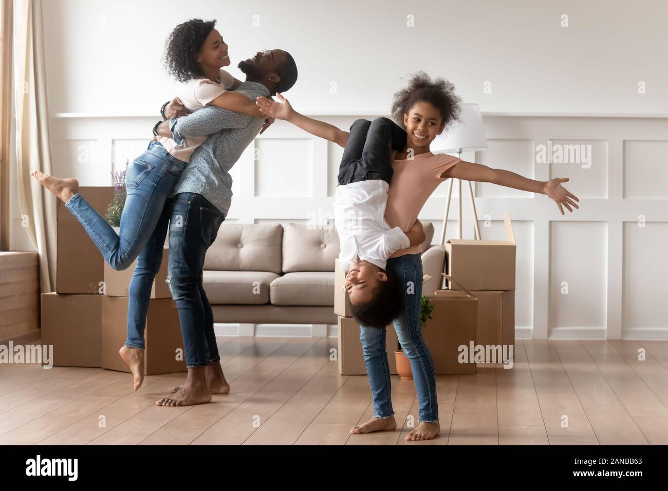Funny mixed race family celebrating moving day. Stock Photo