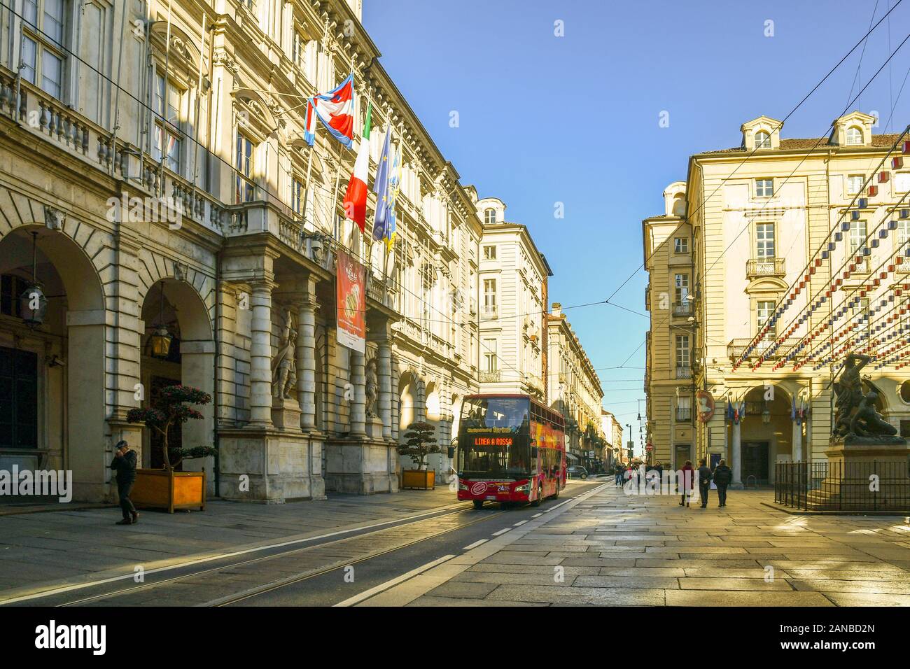 Sightseeing Bus full of tourists passing in front of the Town Hall in Piazza Palazzo di Città square in the historic centre of Turin, Piedmont, Italy Stock Photo