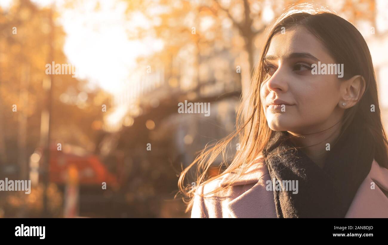 Young beautiful lady enjoying pleasant autumn sunlight dreaming big, inspiration Stock Photo