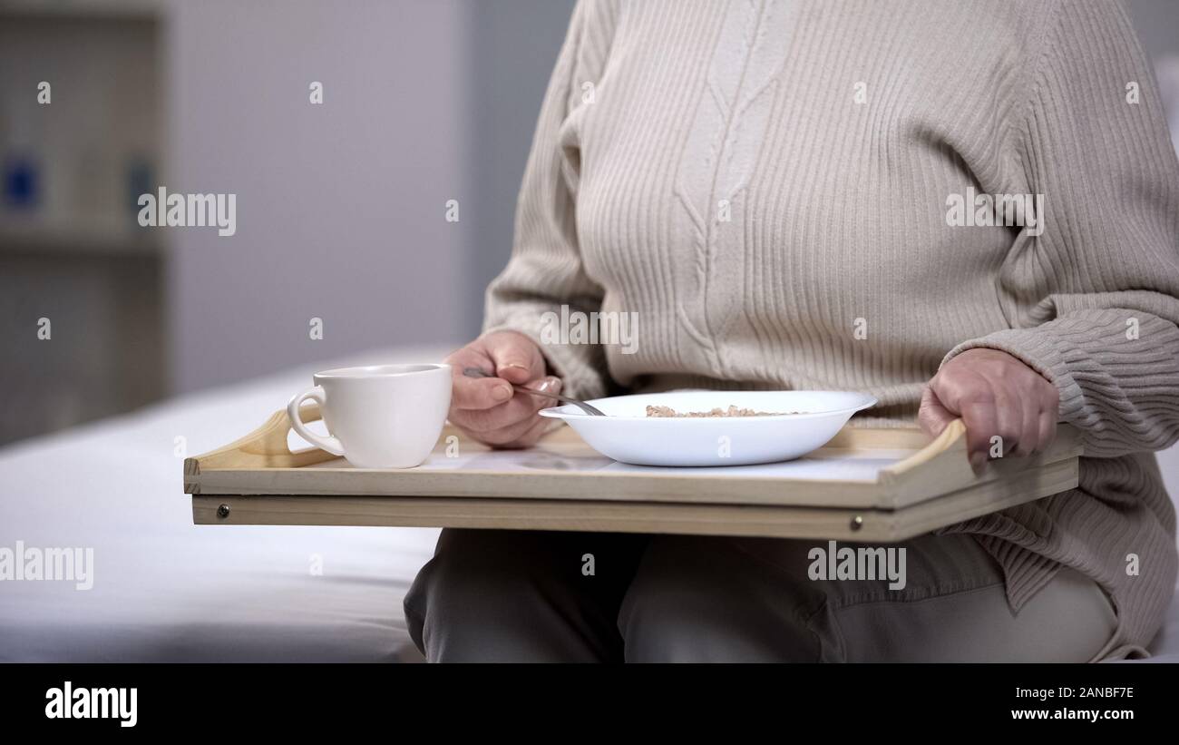 Elderly lady eating diabetic dinner in rehabilitation center, social security Stock Photo