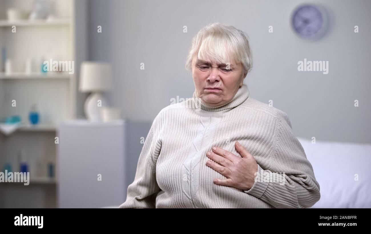 Elderly woman suddenly feeling heart attack, health problems in old age Stock Photo