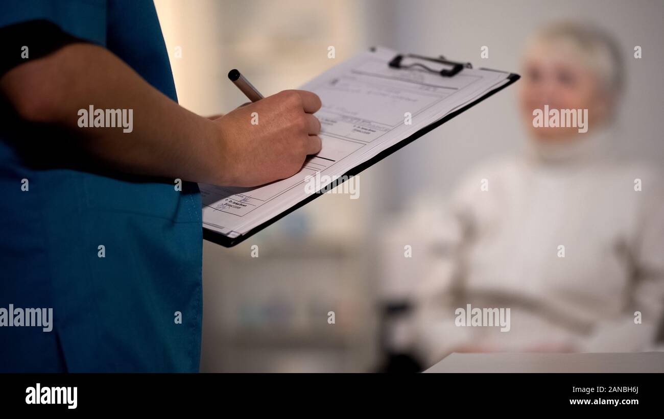 Doctor making notes in medical records, hospital examination, patient ...