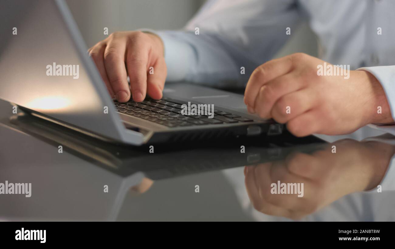 Manager working on laptop preparing report, analyzing information, internet Stock Photo