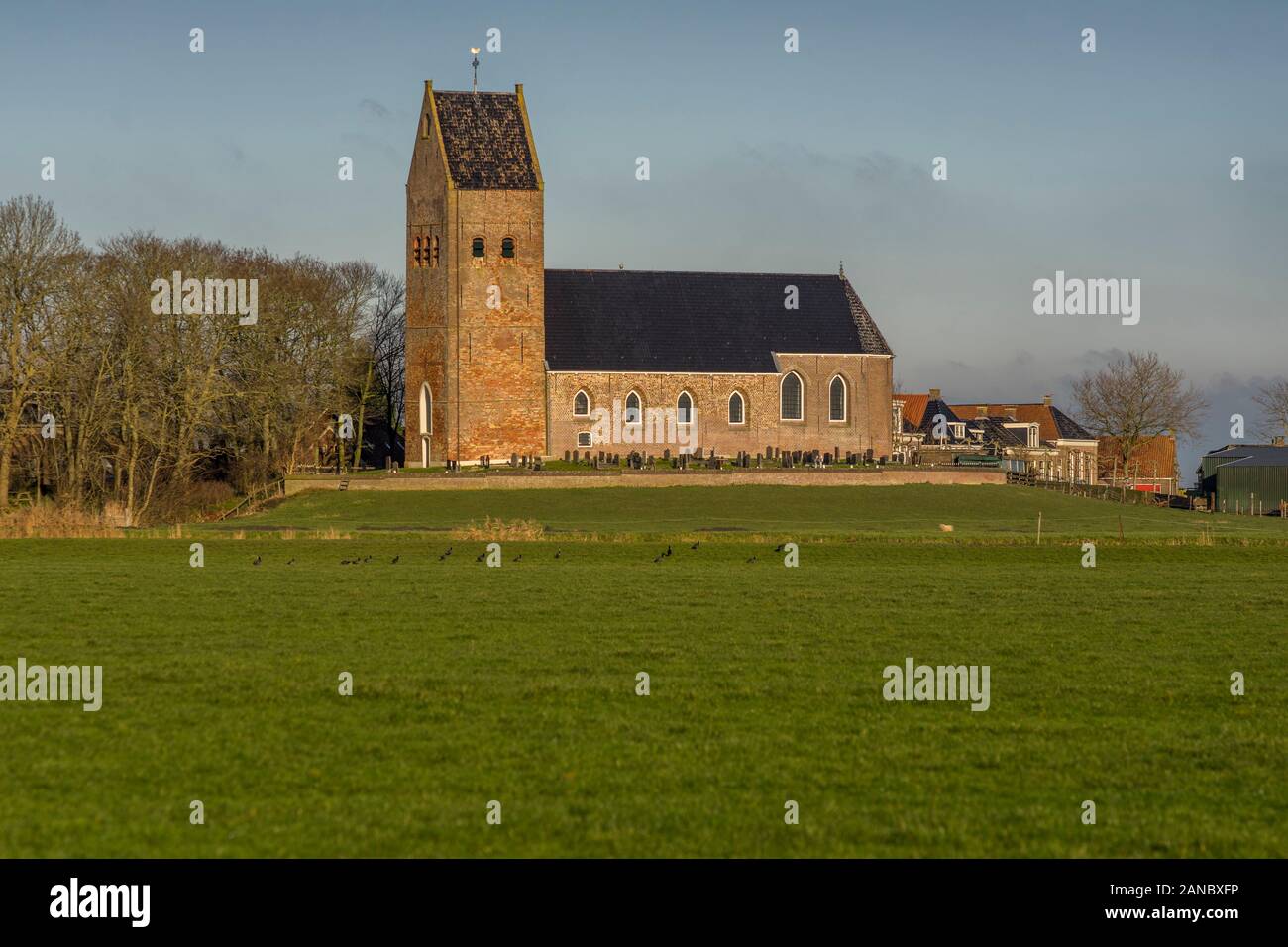 The Reformed Church, surrounded by a cemetery, in Wanswerd stands on a mound, The Netherlands 2019. Stock Photo