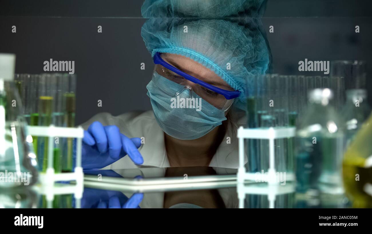 Chemistry student adding experiment data to report on tablet PC