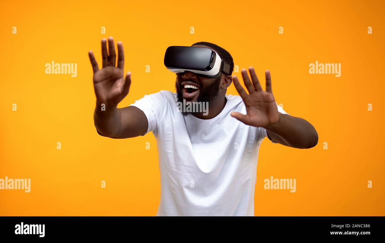 Happy African-American man using VR headset exploring future technologies Stock Photo