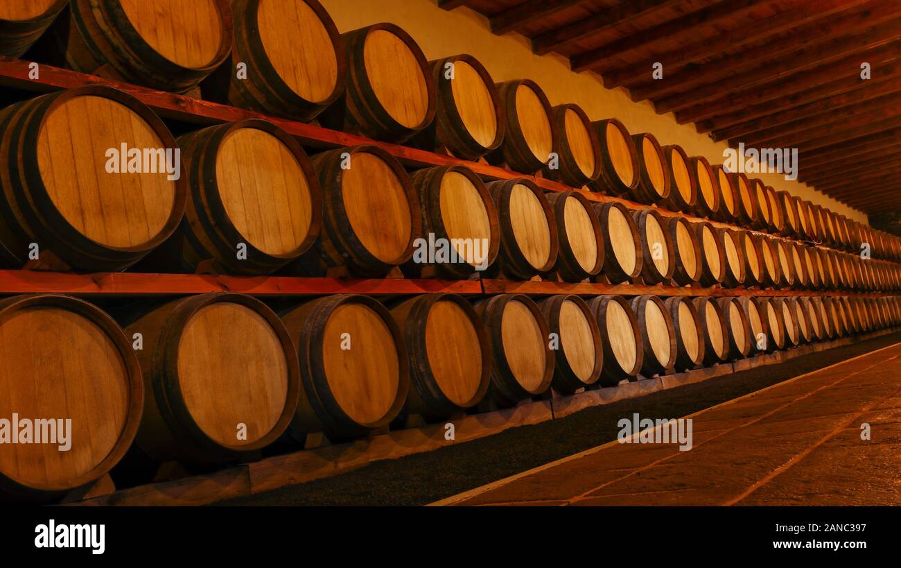 Rows of new oak wine barrels stacked for aging. Stock Photo