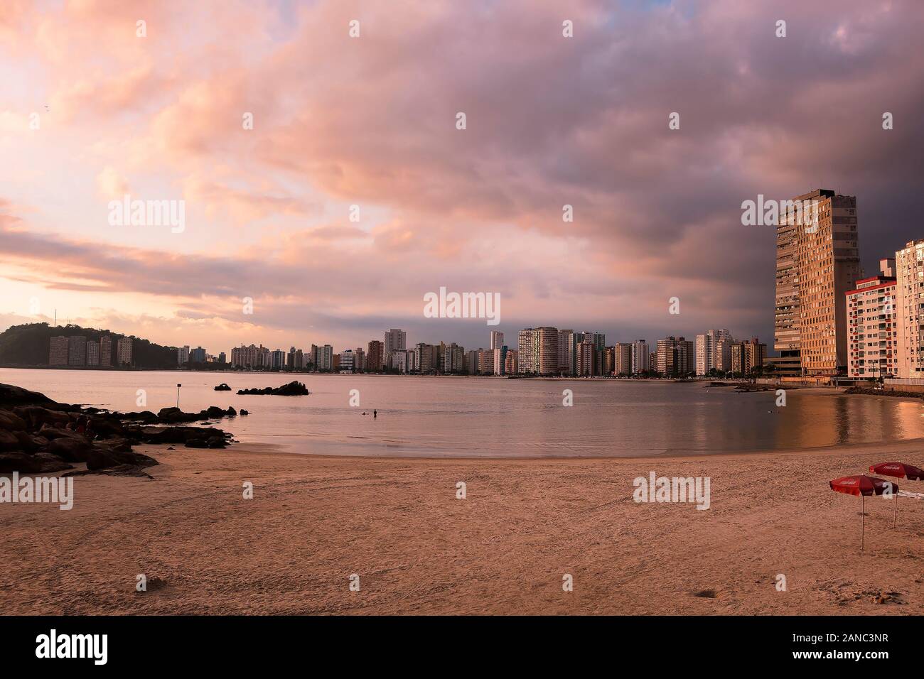 Sao Vicente - SP, Brazil - November 21, 2019: Sunset at Praia dos Milionarios beach, millionaires beach in english and the city on the background. Stock Photo