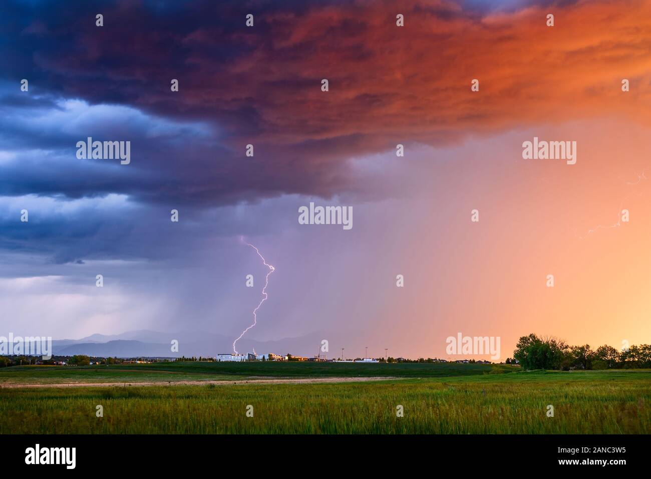 Scenic summer landscape and colorful sunset sky with thunderstorm lightning and heavy rain over Broomfield, Colorado Stock Photo