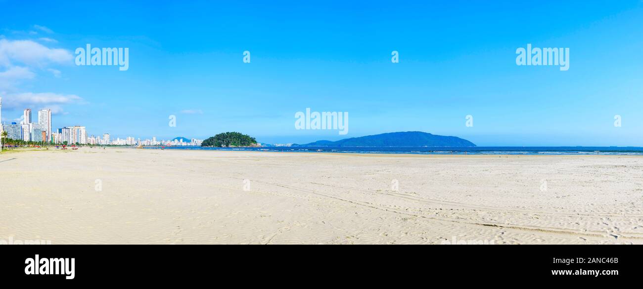 Panoramic view of a brazilian Paulista beach with a huge band of waterfront sand on beautiful day. Photo at Itarare beach, Sao Vicente city with the v Stock Photo
